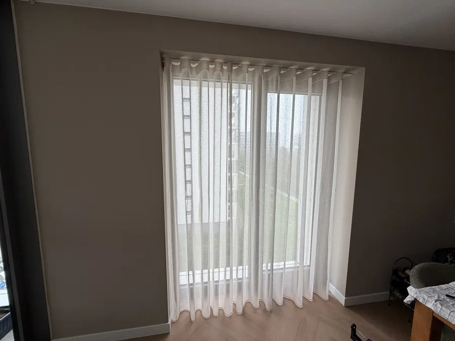 Transparante wave-gordijnen in een modern interieur met houten vloer