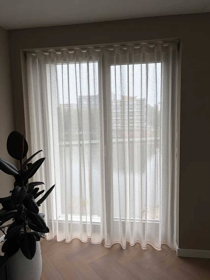 Lichte transparante wave-gordijnen voor hoge ramen in een modern appartement